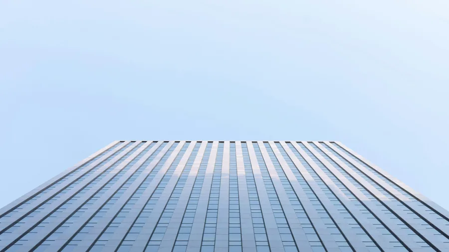 Modern kantoorgebouw — glasgevel tegen blauwe lucht